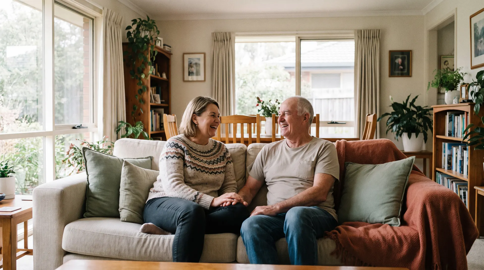 A woman and an older man sitting together on the lounge in a bright, accessible home